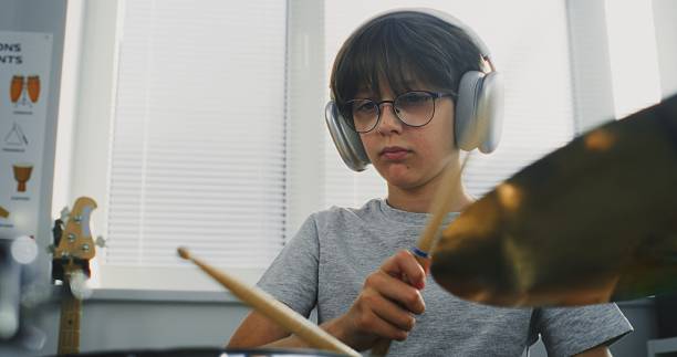 istock Talented Boy Wearing Headphones Playing Drums in Percussion Class, Rehearsing Future Performance 2236681314