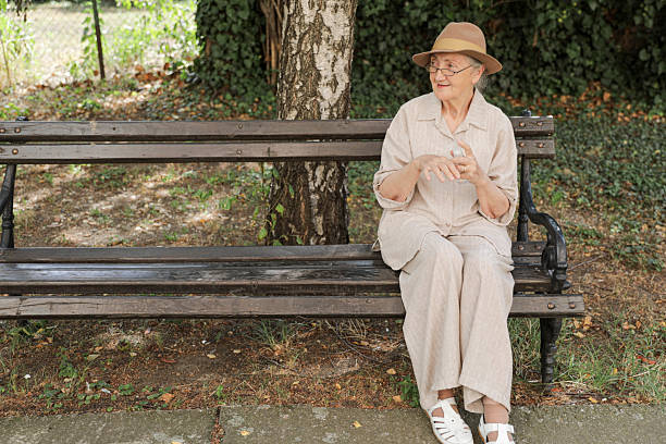 istock Senior Woman In Hat Practicing Hand Hygiene Outdoors 2236683072