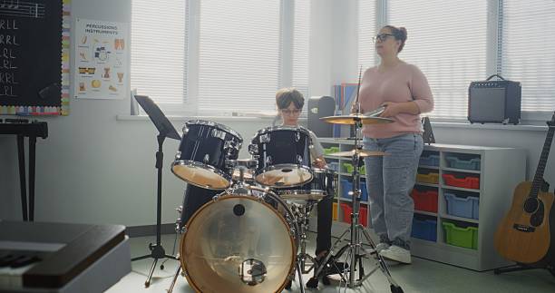istock Primary School Boy Practicing Drums in Modern Music Class. Female Teacher Educating Talented Child 2236683414