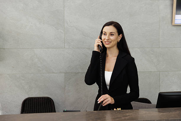 istock Smiling businesswoman talking on phone at reception desk 2236683716