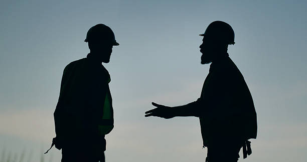 istock Silhouette, construction and engineer team with discussion on site for building. Contractor, inspection and men in collaboration with safety, maintenance and conversation for property development. 2236684709