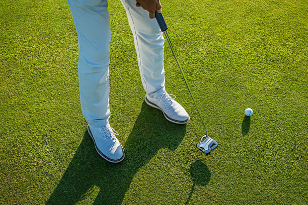 istock Golfer putting ball on green during sunny day 2236684822