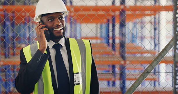 istock Black man, engineer and happy for phone call, construction site or real estate development. Person, contractor and smartphone with smile at property management, contact or report at building in Kenya 2236685229