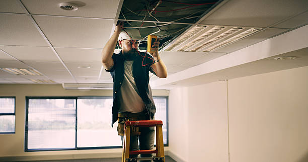 istock Electrician, man and test cable with multimeter for maintenance, voltage or fix energy system. Electricity, wire and worker repair ceiling for power, measure current or office inspection with ladder 2236685253