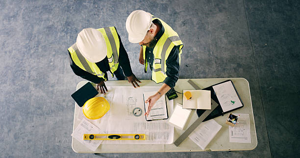 istock Blueprint, meeting and architecture with people and documents for discussion, engineering and contractor. Construction team, floor plan and top view of employee and paperwork for renovation space 2236685254