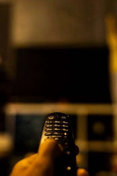 Use the TV remote In Dark Room, authentic home scene designed for electronics marketing, cozy living visuals, and modern lifestyle or leisure content.