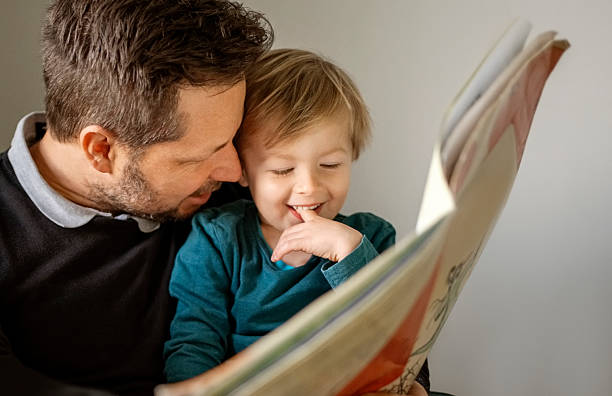 istock Loving father reading a book to his young son at home 2236687363