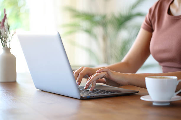 istock Woman hands typing on laptop in a wooden table 2236688530
