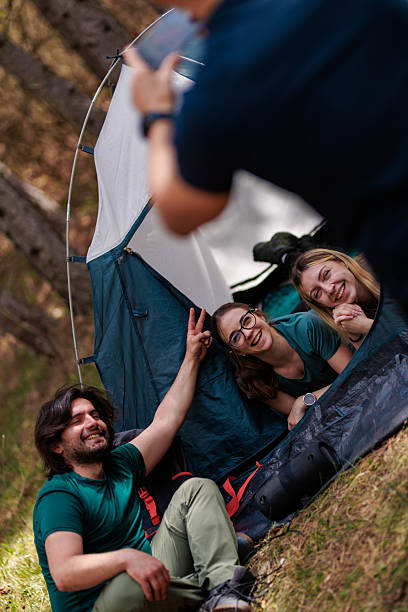 istock Friends enjoying a camping trip in a forest, having fun inside a tent while creating lasting memories with laughter and joy 2236693102