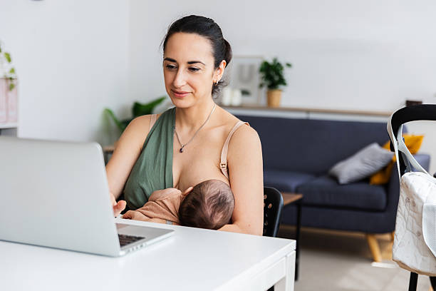 istock Young working mother breastfeeding baby while using laptop at home 2236693133