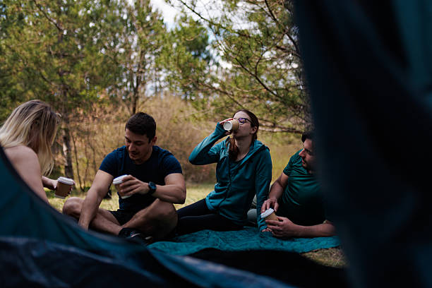istock Enjoying a relaxing camping experience with friends while sipping drinks in a serene outdoor setting 2236693147