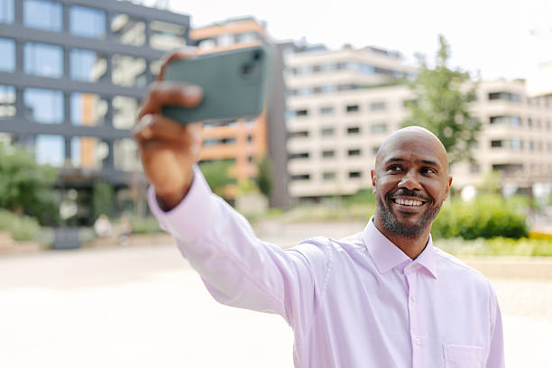 Thoughtful man posing in front of modern buildings