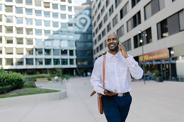 istock Man walking with a tablet and phone outdoors 2236694988