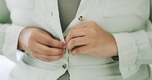 istock Hands, button and fitting suit for style, plus size fashion and overweight with jacket with morning routine in home. Person, garment and decision for clothes, blazer and weight gain at apartment 2236695397