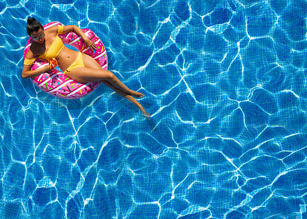 istock Woman in hat relaxing at the pool 2236696339