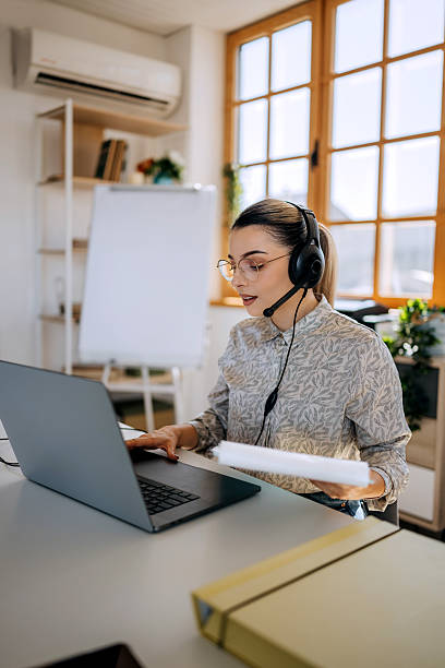 istock Confident businesswoman working with headset at office 2236697575