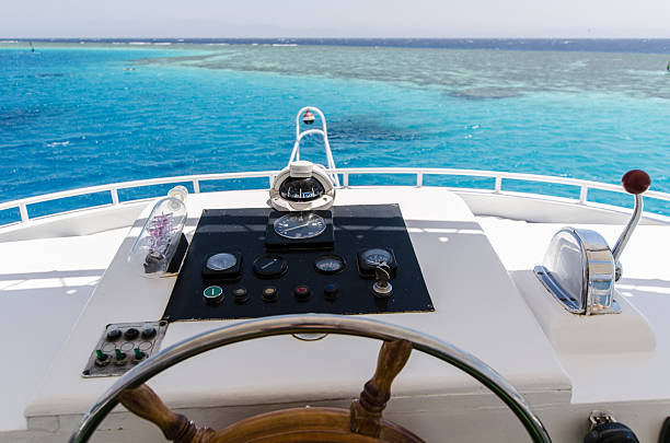 Wooden cockpit of small boat with steering wheel, gauges and cabin interior. Touristic yacht in sea