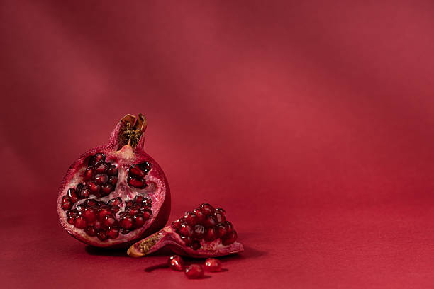 istock Bright burgundy background with fresh juicy pomegranate and copy space 2236700329