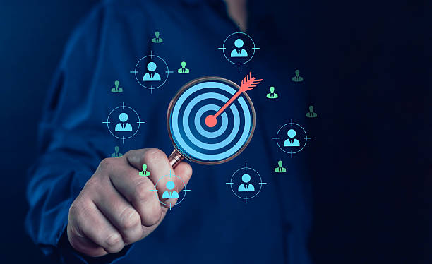 istock Hand holding magnifying glass with digital target and customer icons, symbolizing target audience, business strategy, customer focus, marketing analytics, digital advertising, and market research. 2236702196