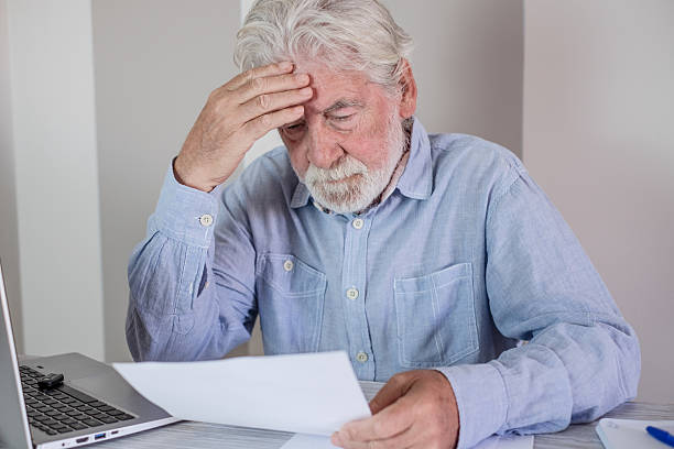 istock Elderly man looking stressed while reading documents at his desk, highlighting financial or administrative concerns. 2236704784