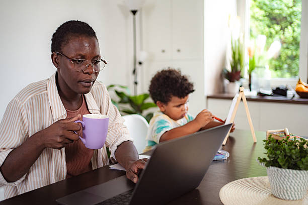 istock Black mother working from home with child drawing 2236706111