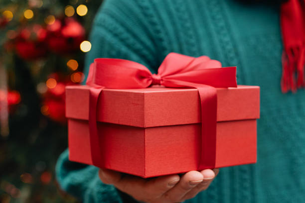 istock Man holding Red Gift Box in Christmas Festive Setting. 2236708369