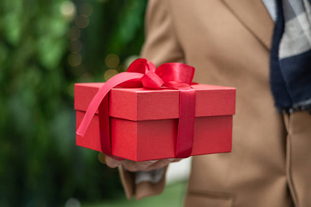 istock Man holding Red Gift Box in Christmas Festive Setting. 2236708658