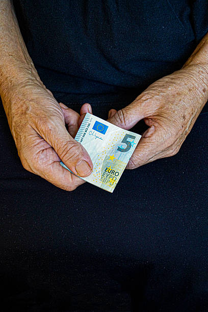 istock An elderly person holds five euros in his hand 2236710023