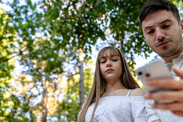 istock Couple Engaged With Smartphone in a Lush Outdoor Park Setting 2236710047