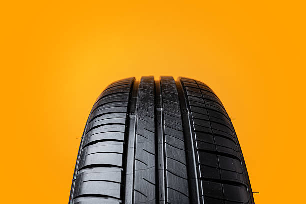 istock Car tires isolated on yellow background, close up 2236710513