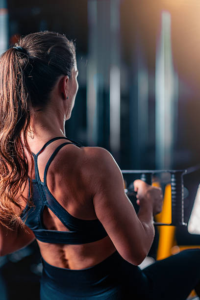istock Using an exercising  machine in the gym, a woman builds back strength and endurance. This targeted workout enhances muscle tone and promotes confidence through effective resistance training. 2236715351