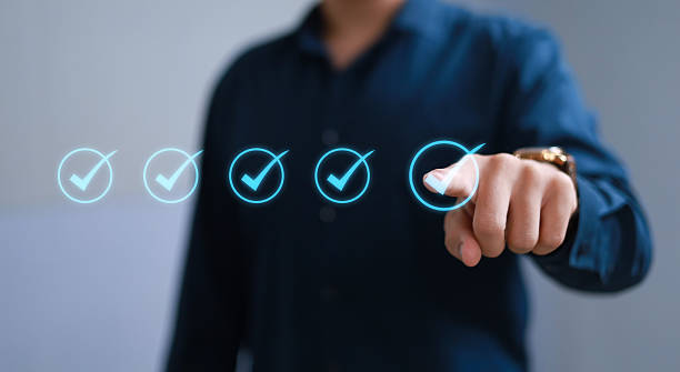 istock Businessman hand selecting check marks, goals and flags to track tasks, process completion and goal achievement. Digitally complete workflow. 2236716035