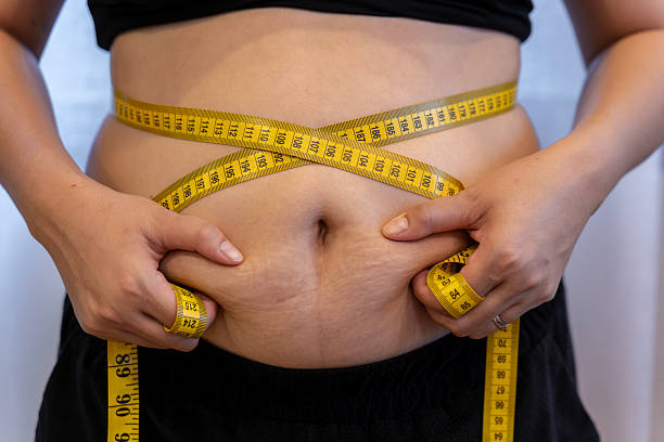 istock Woman squeezing belly fat with her hands 2236717380