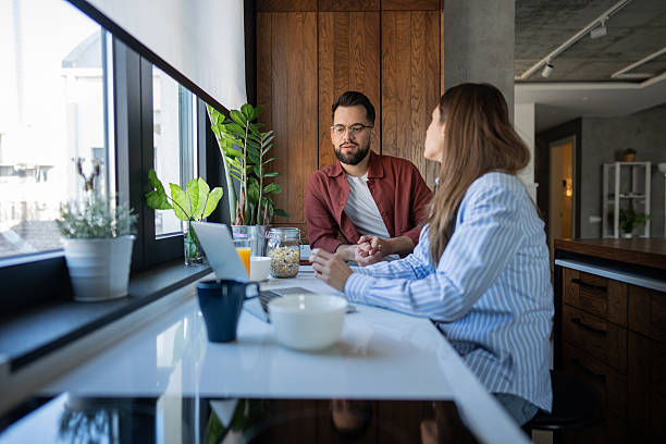 istock Couple talking during morning breakfast in kitchen with laptop 2236717709
