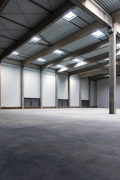 istock The empty interior of a large industrial warehouse. 2236718475