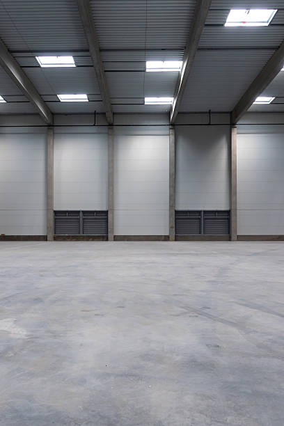 istock The empty interior of a large industrial warehouse. 2236718492