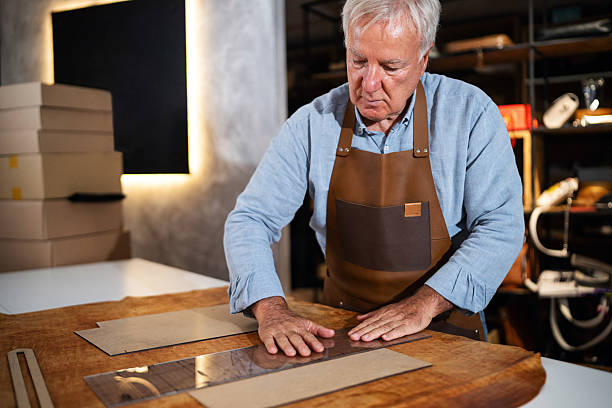 istock Senior craftsman working on crafting leather goods in his workshop 2236718994