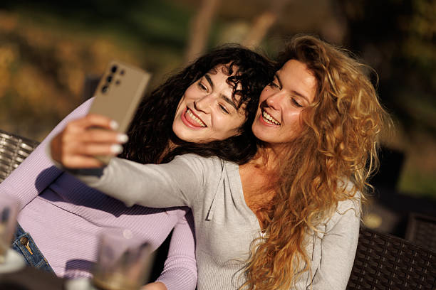 istock Friends capturing a joyful moment together while enjoying drinks outdoors in a warm setting during a sunny afternoon 2236719245
