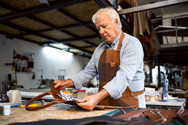 istock Senior craftsman working on leather handbag production in a workshop 2236719545