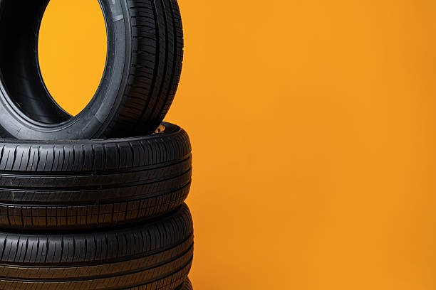 istock Car tires isolated on yellow background, close up 2236722672