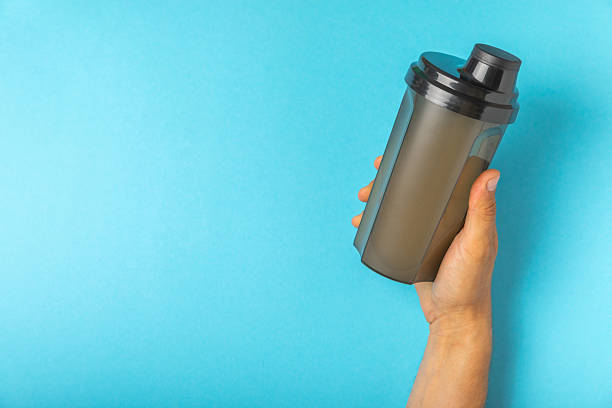 istock Protein shake with protein powder on a colored background. The powder is mixed with water or milk. A dietary supplement for a balanced diet. Whey protein. Fitness and gym diet nutrition. 2236722925