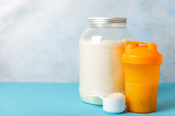 istock Protein shake with protein powder on a colored background. The powder is mixed with water or milk. A dietary supplement for a balanced diet. Whey protein. Fitness and gym diet nutrition. 2236722933