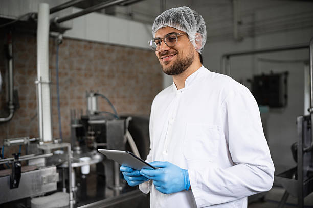 istock Male technician in modern dairy facility holding tablet and smiling 2236723368