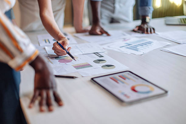 istock Collaborative Team Meeting Discussing Data with Charts and Tablet on Desk 2236724405