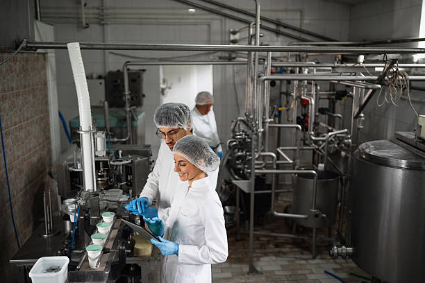 istock Dairy workers operating machinery in food processing factory 2236724796