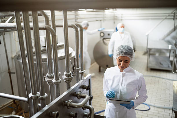 istock Technicians working in a modern dairy processing facility monitoring production equipment 2236725704