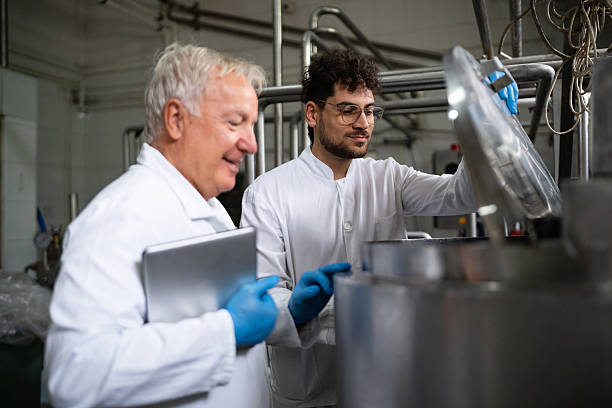 istock Scientists inspecting dairy processing equipment at a milk plant 2236726213