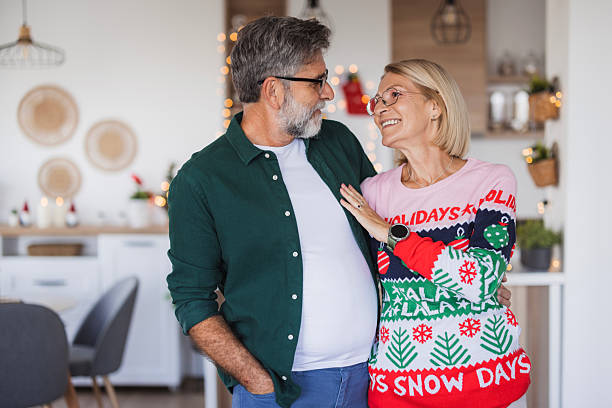 istock Senior couple celebrating holidays at home wearing ugly sweaters 2236726977