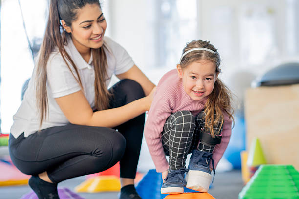 istock Therapist Supports Young Girl With Limb Difference During Balance Exercise In Physical Therapy Session 2236729479