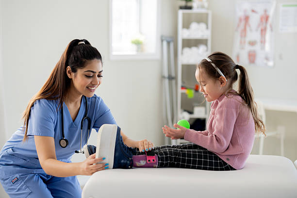 istock Friendly Nurse Helps Child With Leg Therapy During Pediatric Physiotherapy Session 2236731217